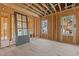 Room under construction featuring windows, a door, and exposed wooden beams at 2605 Hazelwood Dr, Raleigh, NC 27608