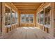Sunroom with unfinished construction, studs, and subfloor, framing bright windows, showcasing the space's potential for airy design at 2605 Hazelwood Dr, Raleigh, NC 27608