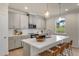 Well-lit kitchen features an island with a quartz countertop, stainless steel appliances and light gray cabinets at 279 Providence Creek Dr, Fuquay Varina, NC 27526