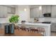 Bright kitchen features light gray cabinets, pendant lighting and a large island with seating at 279 Providence Creek Dr, Fuquay Varina, NC 27526