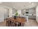 Open floor plan shows kitchen with light gray cabinets, stainless steel appliances, island with seating, and dining table at 279 Providence Creek Dr, Fuquay Varina, NC 27526