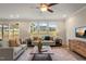 Living room with a ceiling fan, large windows offering ample natural light, and comfortable seating at 279 Providence Creek Dr, Fuquay Varina, NC 27526