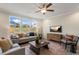 Bright living room with large windows providing natural light, comfortable seating, ceiling fan and backyard views at 279 Providence Creek Dr, Fuquay Varina, NC 27526