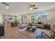 Spacious living room with large windows, ceiling fan, and view into dining room and kitchen at 279 Providence Creek Dr, Fuquay Varina, NC 27526
