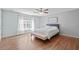 Spacious bedroom with light-filled windows, hardwood flooring, and a comfortable bed with white linens at 2909 Timpani Trl, Apex, NC 27539