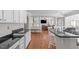 Elegant kitchen with white cabinets, an island with bar stools, and an open view to living area at 2909 Timpani Trl, Apex, NC 27539
