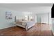 Light-filled main bedroom featuring hardwood floors and neutral decor at 2909 Timpani Trl, Apex, NC 27539