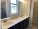 Bathroom with double vanity, quartz countertops, and window view of neighborhood at 293 Providence Creek Dr, Fuquay Varina, NC 27526