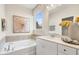 Bright bathroom with a soaking tub, vanity and a view to the outdoors at 293 Providence Creek Dr, Fuquay Varina, NC 27526