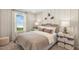 Cozy bedroom with a wicker headboard, soft bedding, and ample natural light streaming through the window at 293 Providence Creek Dr, Fuquay Varina, NC 27526