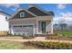 Charming home featuring a brick pathway, two-car garage, and a welcoming front porch area at 293 Providence Creek Dr, Fuquay Varina, NC 27526