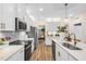 Modern kitchen featuring white cabinets, stainless steel appliances, a large island, and hardwood floors at 293 Providence Creek Dr, Fuquay Varina, NC 27526