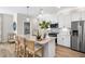 Modern kitchen featuring white cabinets, stainless steel appliances, a large island, and bar stool seating at 293 Providence Creek Dr, Fuquay Varina, NC 27526
