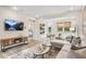 Spacious living room includes modern decor, ample seating, and a view of the backyard through large windows at 293 Providence Creek Dr, Fuquay Varina, NC 27526