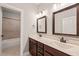 Bathroom featuring double vanity, framed mirrors, and a tiled shower with a glass door at 2936 Turning Brook Ln, Raleigh, NC 27616