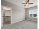 This bedroom features neutral walls, grey carpet, a ceiling fan, and a window that allows natural light at 2936 Turning Brook Ln, Raleigh, NC 27616