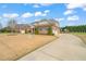 Brick home with a long driveway, mature trees, and front yard at 2936 Turning Brook Ln, Raleigh, NC 27616