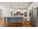 Gourmet kitchen with stainless steel appliances, gray island, granite countertops, and custom cabinetry at 2936 Turning Brook Ln, Raleigh, NC 27616