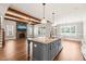 Open concept living area with stone fireplace, wood beams, and kitchen island at 2936 Turning Brook Ln, Raleigh, NC 27616