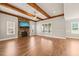 Open living room features wood beams, a fireplace with stone accents, and abundant natural light at 2936 Turning Brook Ln, Raleigh, NC 27616