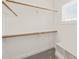 A walk-in closet with wooden clothing rods, a built-in bench, and white shelving creates ample storage space at 2936 Turning Brook Ln, Raleigh, NC 27616