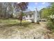 Expansive backyard featuring a lush lawn and mature trees surrounding the white exterior of the home at 2949 Tram Rd, Fuquay Varina, NC 27526