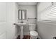 Charming half bathroom featuring a pedestal sink, toilet, and window with blinds at 2949 Tram Rd, Fuquay Varina, NC 27526