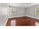 Bedroom features hardwood floors, a ceiling fan, two windows for natural light, and a neutral color palette at 2949 Tram Rd, Fuquay Varina, NC 27526