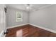 Bedroom features gleaming hardwood floors, ceiling fan, window with natural light, and neutral color palette at 2949 Tram Rd, Fuquay Varina, NC 27526