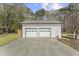 Large two car garage with a concrete driveway and mature landscaping at 2949 Tram Rd, Fuquay Varina, NC 27526