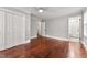 Main bedroom features gleaming hardwood floors, a ceiling fan, closet, and open door to bathroom at 2949 Tram Rd, Fuquay Varina, NC 27526