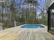 Large above ground pool surrounded by a wooden deck in a wooded back yard at 2949 Tram Rd, Fuquay Varina, NC 27526