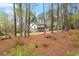 Exterior view of the home surrounded by trees, greenery, and a colorful azalea bush at 302 Rutherglen Dr, Cary, NC 27511