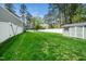 Spacious backyard featuring lush green grass, a storage shed, and a pristine white privacy fence at 321 Third Ave, Knightdale, NC 27545