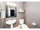 Powder room features pedestal sink, toilet, and decorative shelf at 321 Third Ave, Knightdale, NC 27545