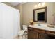 Bathroom vanity with dark cabinets and granite top, featuring a shower at 321 Third Ave, Knightdale, NC 27545