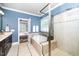 Bathroom with a soaking tub, walk-in glass shower, and light blue walls at 321 Third Ave, Knightdale, NC 27545