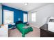 Bedroom with a blue accent wall and two windows offering natural light at 321 Third Ave, Knightdale, NC 27545