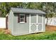 A well-maintained backyard shed, complete with classic doors, a window, and tidy, painted wood at 321 Third Ave, Knightdale, NC 27545