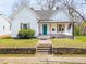 Charming home featuring a quaint front porch and inviting curb appeal with stone retaining wall at 323 W 5Th St, Burlington, NC 27215