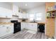 Bright kitchen with white cabinets, black appliances, butcher block counters and wooden shelving at 323 W 5Th St, Burlington, NC 27215