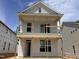 Two-story home with a covered porch and bright white siding, in mid-construction at 324 White Oak Garden Way # 219, Garner, NC 27529