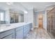 Bright bathroom featuring double sinks, a large mirror, and a glass enclosed shower at 358 Ashpole Trl, Clayton, NC 27520