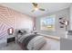 Bedroom with a colorful geometric accent wall, neutral walls, and a ceiling fan at 358 Ashpole Trl, Clayton, NC 27520