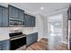 Charming kitchen featuring gray cabinetry, stainless steel appliances, quartz countertops, and hardwood floors at 358 Ashpole Trl, Clayton, NC 27520
