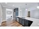 Charming kitchen featuring gray cabinetry, stainless steel appliances, quartz countertops, and hardwood floors at 358 Ashpole Trl, Clayton, NC 27520