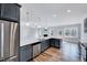 Charming kitchen featuring gray cabinetry, stainless steel appliances, quartz countertops, and hardwood floors at 358 Ashpole Trl, Clayton, NC 27520
