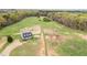 Aerial view of a farm featuring a home, barns, and equestrian training facilities at 3880 L Lawrence Trl, Graham, NC 27253