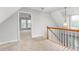 Bright hallway with open doorway and wooden banister at 3880 L Lawrence Trl, Graham, NC 27253
