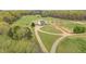 Aerial view of a home with a vast lawn area, complemented by mature trees, and a winding gravel driveway at 3880 L Lawrence Trl, Graham, NC 27253